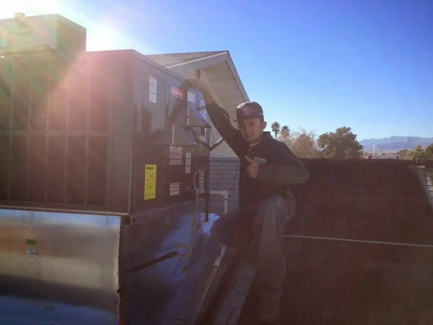 HVAC technician performing AC Tune-Up on a rooftop unit in Homer Glen